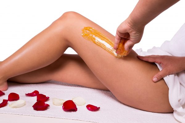 Sugaring: epilation with liquate sugar at legs.